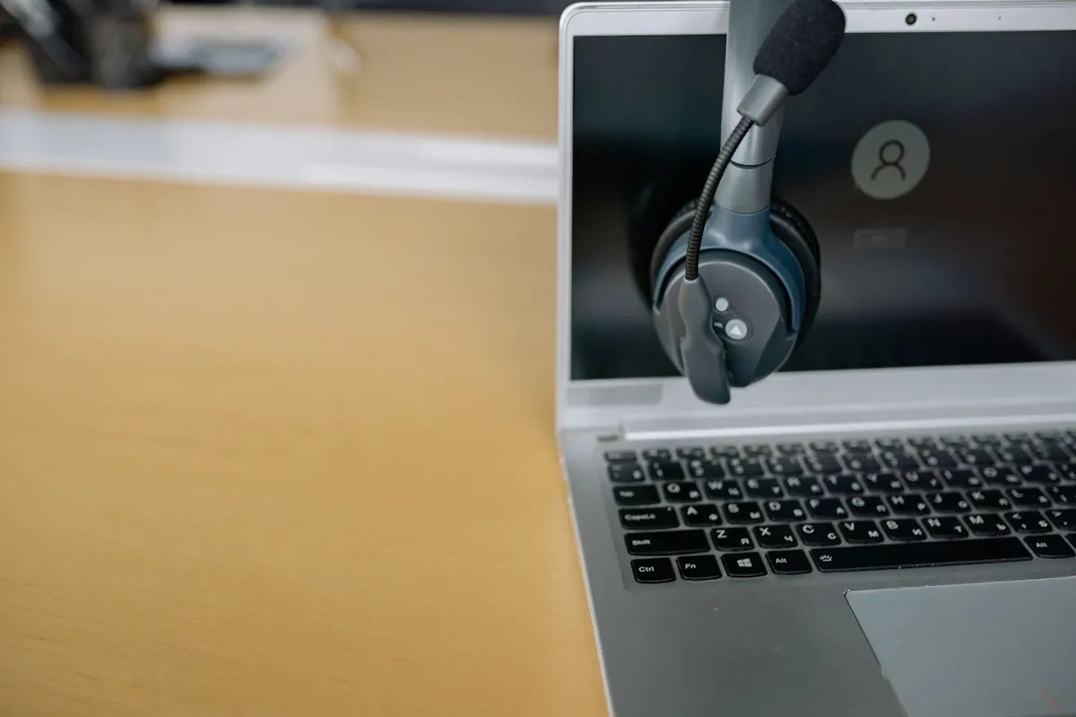 Headset de atendimento sobre notebook - atendente de IA que responde 24 horas na Poupar AI